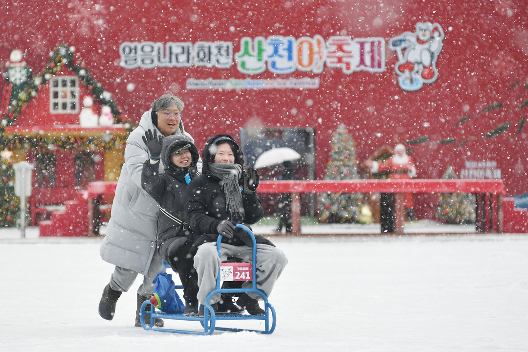 2026 화천산천어축제 개막 사흘째인 12일, 함박눈이 내리는 가운데 관광객들이 얼음썰매 체험을 즐기고 있다. 

