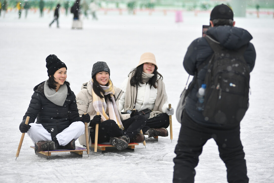 2026 화천산천어축제 개막 사흘째인 12일, 함박눈이 내리는 가운데 관광객들이 얼음썰매 체험을 즐기고 있다. 

